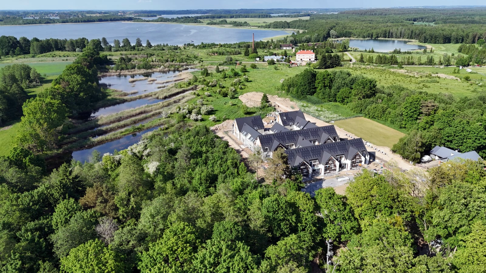 Panorama Yacht Apartment z jeziorem, terenami zielonymi i zabudową widziana z drona