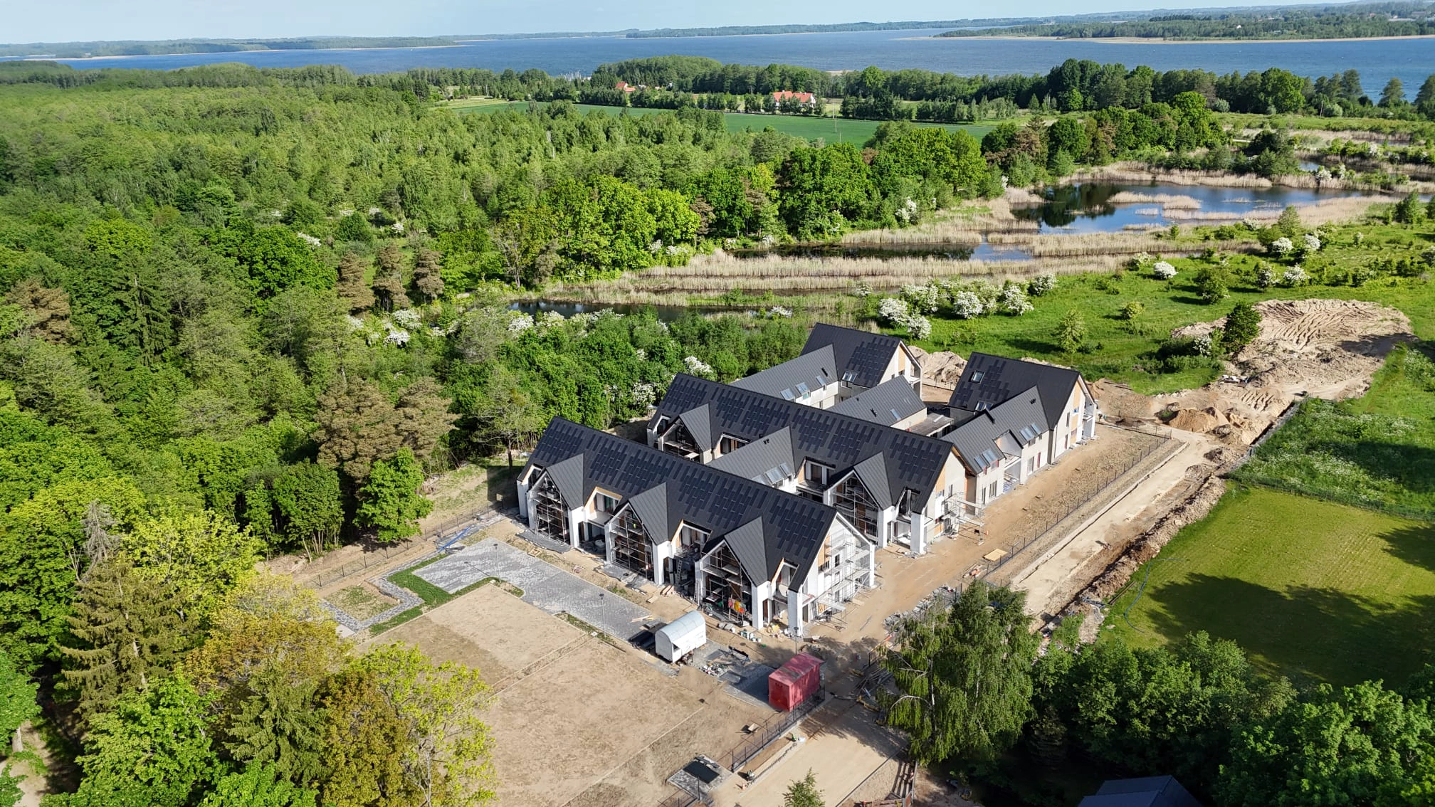 Kompleks Yacht Apartment oraz zielone tereny wokół jeziora widziane z drona