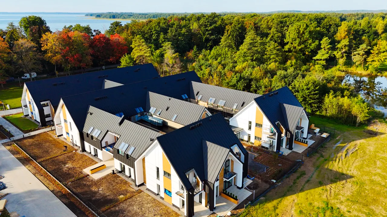 Boczna elewacja Yacht Apartment z drewnianymi detalami, alejką i terenem wokół budynków