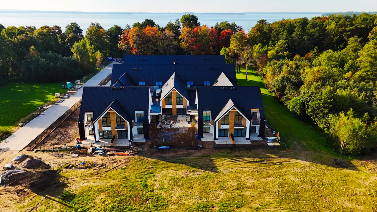 Budynki Yacht Apartment widziane z lotu ptaka w bezpośrednim otoczeniu lasu i zieleni
