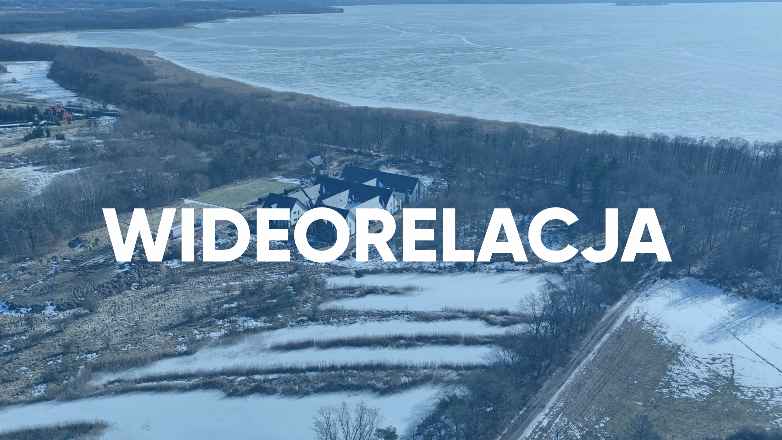 Zimowe ujęcie z drona inwestycji Yacht Apartment nad jeziorem – kadr z wideorelacji